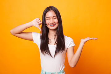 Young Asian woman show palm hand and thumbs down.