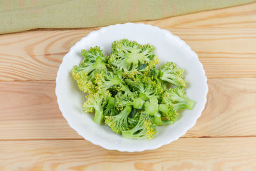 Pieces of broccoli on a dish on wooden rustic table
