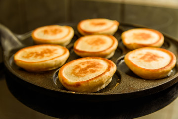 Pancakes in hot cast iron skillet.