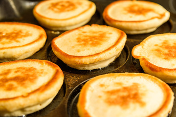 Pancakes in hot cast iron skillet.