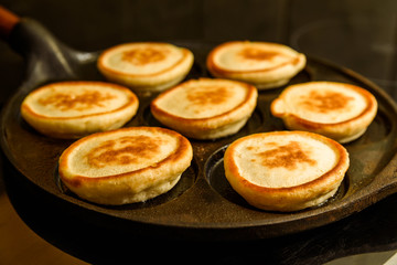 Pancakes in hot cast iron skillet.