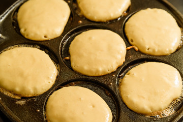 Pancake dough in hot cast iron skillet.