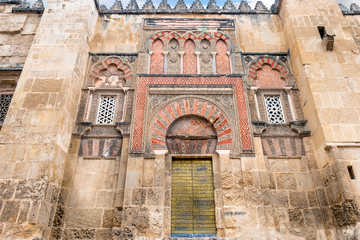 The Mosque Cathedral in Cordoba, Spain. Exterior wall with great golden door - famous landmark in Andalusia
