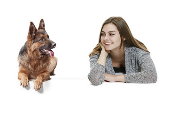 The smiling happy woman and her dog over white background. Shetland Sheepdog sitting in front of a white studio background. The concept of humans and animals same emotions
