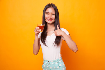 Young Asian woman thumbs up with tomato juice.