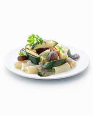 Penne pasta with vegetables on white plate, close-up