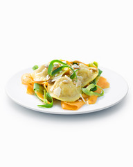 Ravioli with vegetable ribbons on white plate