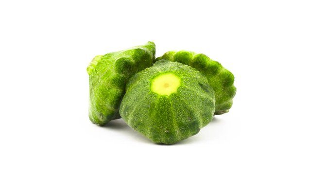 Three whole green pattypan summer squash rotating. Isolated on the white background. Close-up. Macro.