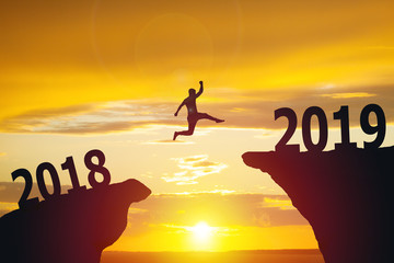 Silhouette of business man jumping from 2018 to 2019