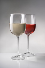 Glasses of expensive red and white wines on table