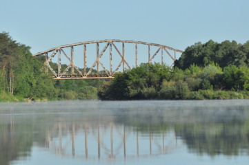Naklejka premium Railway bridge over the river. Bug valley. View of the metal structure of the river.