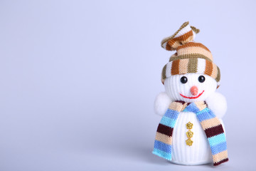 Small snowman toy on a grey background