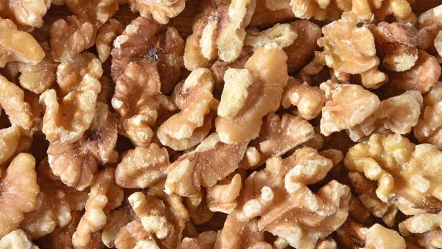 A bowl of chopped walnuts and a cutting board