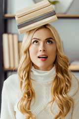 close up of funny woman with books on head