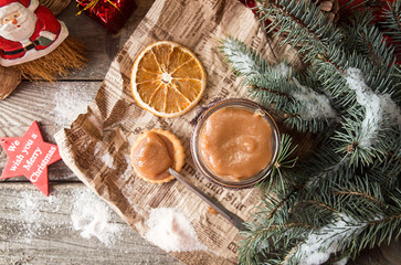 Jar of salt caramel and Christmas decorations.Copy space. Top view.Rustic wooden background.