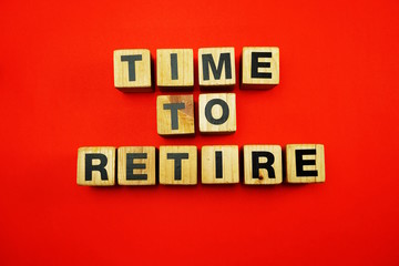time to retire word created with cubes alphabet letters on blue background