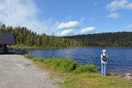 Touristin schaut auf den Kierats See bei Jokkmokk