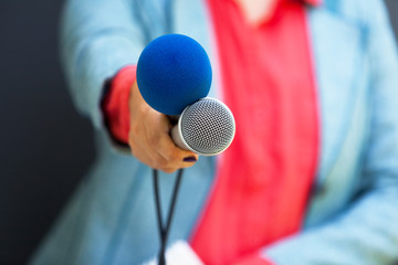 Female journalist at a news conference holding microphone