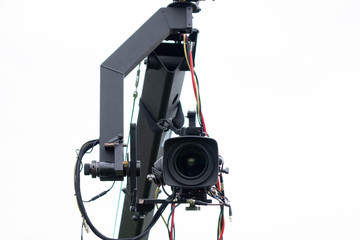 Technology equipment tv digital video camera on a crane isolated on the cloudy sky background with a copy space