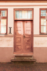 A pink front door front way of an old house in Europe