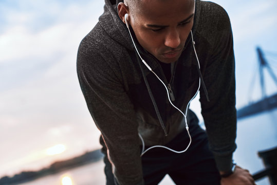 Tired Because Of Running. Young Jogger Is Stopped To Catch His Breath