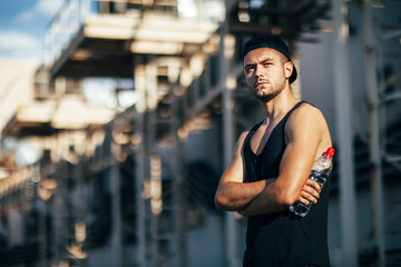 Fototapeta premium Serious handsome man posing on industrial background