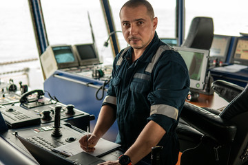 Fototapeta na wymiar Marine navigational officer or technician is using laptop or notebook at sea. Job at sea