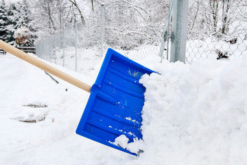 Man removing snow from the sidewalk after snowstorm.