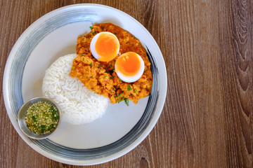 Rice served with fried Hepatopancreas shrimps and have boiled fever on top. The sauce is made from chili as a side dish. This is a typical Thai food.