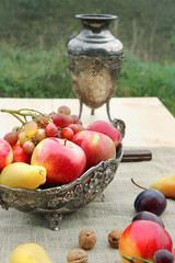 autumn still life. apples, pear and grapes in old bowl