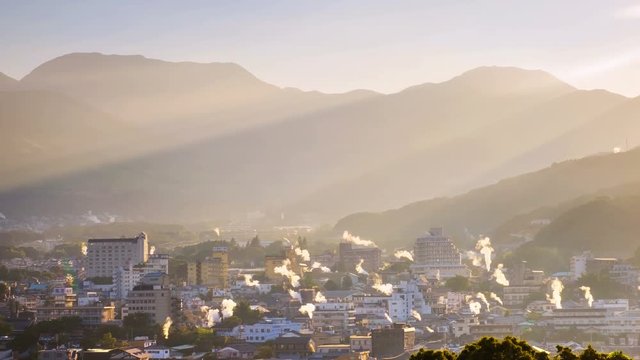 Beppu, Japan. A sunset time-lapse in a resort town of Beppu, Japan, with a view of mountains embracing the city and layers of sun. Zoom in