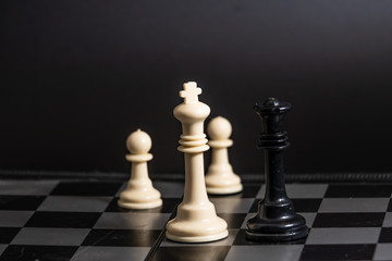 Plastic chess closeup on a black background. A game