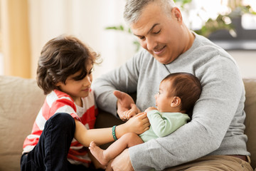 family, fatherhood and people concept - happy father with preteen and baby son at home