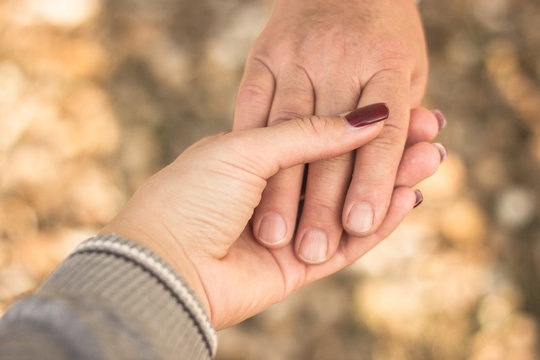 Senior and young hands, bokeh background