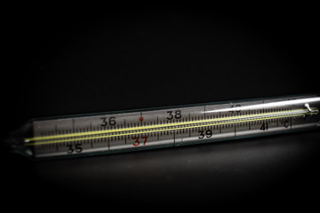 Thermometer for measuring body temperature on a black background