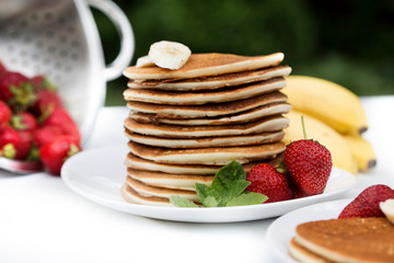 Homemade pancakes with fresh strawberries and honey.