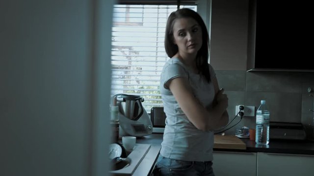Upset, miserable woman suffering in the kitchen