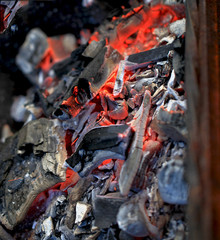 burning coals in the barbecue on a blurred background, the texture of the flame