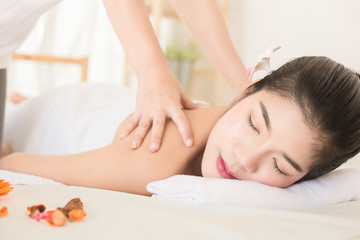 Young asian woman enjoying relaxing back massage in spa. Body care, skin care, wellness, alternative medicine and relaxation Concept.