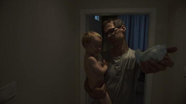 Father holding a son and dirty diaper