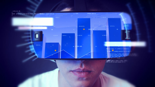 Young man wearing VR headset and watching business and economy related graphics.