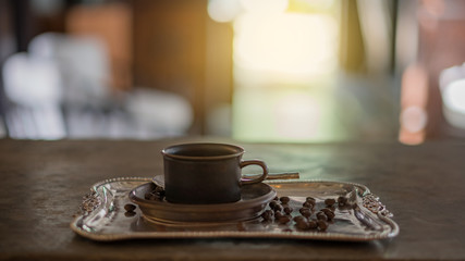Cup of coffee and coffee beans on a silver background tray