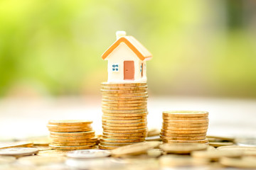 Mini house on stack of coins. Business and finance, House and property investment and asset management, Loan, Mortgage, Inflation, Sale and tax rise and Saving money for buy or rent home concept.