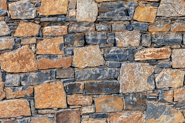 beautiful stone wall of stones of different colors close up, horizontal