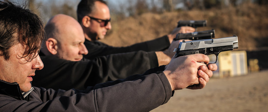 Group of people practice gun shooting on outdoor shooting range