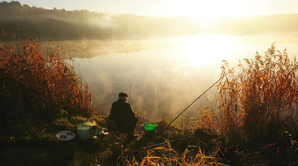 Amatorski wędkarz łowi na jesieni w jeziorze - obrazy, fototapety, plakaty