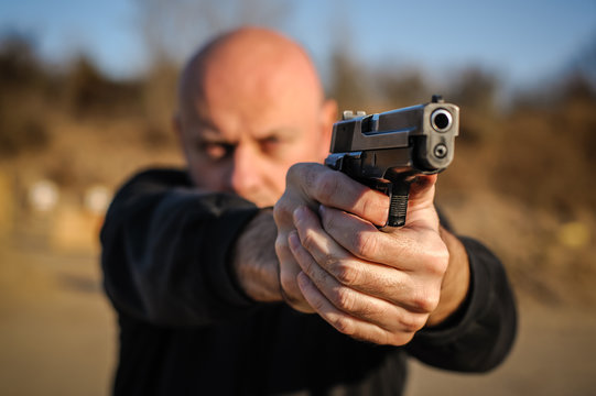 Police Agent Bodyguard Gun Pointing Pistol To Attacker. Front View