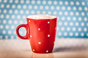 Polka dots red cup of coffee on dark background