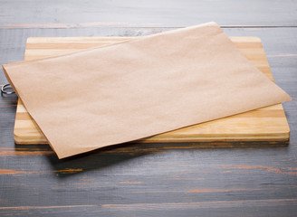 cutting board and parchment lay on a dark wooden tabletop