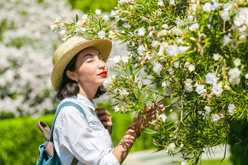 Young woman in spring orchard smilling flowers